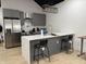 Modern eat-in kitchen with an island featuring gray cabinets, stainless steel appliances, and a stylish lighting fixture at 1518 S Talbott St, Indianapolis, IN 46225