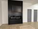 Modern living room featuring a sleek fireplace and tv built-in, two gray doors, and wood flooring at 1518 S Talbott St, Indianapolis, IN 46225