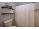 Cozy bathroom with wood shelves, patterned shower curtain and soft lighting at 15388 Follow Dr, Noblesville, IN 46060