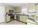 Updated kitchen featuring stainless steel appliances, granite countertops, and light green cabinetry at 15411 Wandering Way, Noblesville, IN 46060