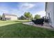 Spacious backyard with a patio, grill, lush green grass, and sunny sky at 15710 Chapel Park E Dr, Noblesville, IN 46060
