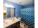 Blue bathroom featuring double sink vanity and shower with geometric-patterned curtain at 15710 Chapel Park E Dr, Noblesville, IN 46060