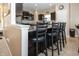 Kitchen island with granite countertop and black stools. Complete with dark wood cabinetry and stainless steel appliances at 15710 Chapel Park E Dr, Noblesville, IN 46060