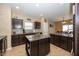 Modern kitchen with dark cabinetry, granite countertops, and an island, offering ample workspace at 15710 Chapel Park E Dr, Noblesville, IN 46060