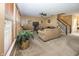 Open-concept living room with cozy furniture, leading to a staircase and other living areas at 15710 Chapel Park E Dr, Noblesville, IN 46060