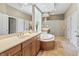 Bright bathroom featuring double sinks, a large mirror, and a soaking tub at 16502 Grand Cypress Dr, Noblesville, IN 46060