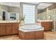 Relaxing bathroom featuring a soaking tub, double sinks, and a view of a window at 16502 Grand Cypress Dr, Noblesville, IN 46060