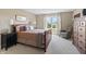 Bright bedroom featuring a large window, neutral walls, and a wood sleigh bed with cozy bedding at 16502 Grand Cypress Dr, Noblesville, IN 46060