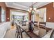 Formal dining room with a chandelier, hardwood table, and seating, open to the living room beyond at 16502 Grand Cypress Dr, Noblesville, IN 46060