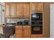 Close-up of a kitchen featuring wood cabinets, granite countertops, and modern appliances at 16502 Grand Cypress Dr, Noblesville, IN 46060