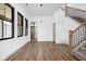 Bright living room with elegant hardwood floors, a staircase, and large windows that flood the space with natural light at 1664 Carrollton Rail Dr, Westfield, IN 46074