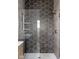 Modern shower with unique tiling, glass door, and shelving for toiletries at 1664 Carrollton Rail Dr, Westfield, IN 46074