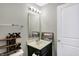 A gray-toned bathroom with a modern vanity, light fixture, and artwork, complemented by a distinctive tic-tac-toe shelf at 1664 Woodside Cir, Franklin, IN 46131