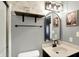 Cozy bathroom with modern sink, patterned wallpaper, and black-trimmed, arched mirrors at 1664 Woodside Cir, Franklin, IN 46131