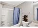 This bathroom features a bathtub-shower combination with blue curtain, toilet and a stylish wooden tic-tac-toe shelf at 1664 Woodside Cir, Franklin, IN 46131