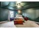 This bedroom features green walls and ceiling, with carpet flooring, and has a four-poster bed with modern decor at 1664 Woodside Cir, Franklin, IN 46131