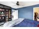 Bedroom with dark blue walls, ceiling fan, and bookcase at 1664 Woodside Cir, Franklin, IN 46131