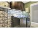 Functional laundry area with stylish wallpaper, cabinets, and stainless steel Maytag appliances at 1664 Woodside Cir, Franklin, IN 46131