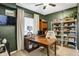 A well-lit home office featuring a large wooden desk, custom shelving, and a cozy, inviting atmosphere at 1664 Woodside Cir, Franklin, IN 46131