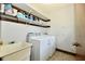 Bright laundry room with washer, dryer, utility sink, and shelf storage above at 18906 Crestview Ct, Westfield, IN 46074