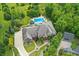 Aerial view of the property featuring a large brick home, pristine pool, and circular drive at 20170 Starlight Ct, Noblesville, IN 46062