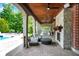 Relaxing covered patio featuring a stone fireplace, comfortable seating and open views of the pool and backyard at 20170 Starlight Ct, Noblesville, IN 46062