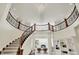 An opulent foyer showcases a curved staircase, railing, and crystal chandelier at 20170 Starlight Ct, Noblesville, IN 46062