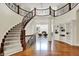 Grand foyer featuring a curved staircase, dark wood accents, and bright white walls at 20170 Starlight Ct, Noblesville, IN 46062