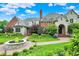 View of a well landscaped circular driveway with a water feature in the yard of the home at 20170 Starlight Ct, Noblesville, IN 46062