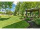 Landscaped backyard with a pond view, a gazebo with comfortable seating, and mature trees creating a serene outdoor retreat at 24 Cinnamon Ct, Brownsburg, IN 46112