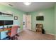 Well-lit office with a large desk, comfortable seating, and a wall-mounted television at 24 Cinnamon Ct, Brownsburg, IN 46112