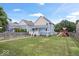 Spacious backyard featuring a lawn, playset, wooden fence, and garden beds at 2448 Broadway St, Indianapolis, IN 46205