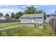 The backyard showcases a detached garage, green lawn, defined garden beds, and a light blue color scheme at 2448 Broadway St, Indianapolis, IN 46205