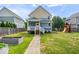 Inviting backyard with a charming two-story home, a swing set, raised garden beds, and a well-kept lawn at 2448 Broadway St, Indianapolis, IN 46205