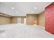 Spacious basement featuring neutral carpeting, recessed lighting, and a unique red brick accent wall at 2448 Broadway St, Indianapolis, IN 46205