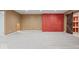 Basement area showcasing plush carpeting, red brick wall, and rustic sliding barn door with shelving at 2448 Broadway St, Indianapolis, IN 46205