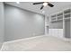 Bedroom features gray walls, neutral carpeting, a ceiling fan, and custom white built-in shelving with drawers at 2448 Broadway St, Indianapolis, IN 46205