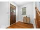 Bright foyer with hardwood floors, a stylish cabinet, and natural light streaming through the window at 2448 Broadway St, Indianapolis, IN 46205