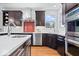 Bright kitchen featuring stainless steel appliances, dark cabinetry, quartz countertops, and red backsplash at 2448 Broadway St, Indianapolis, IN 46205