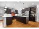 A modern kitchen with stainless steel appliances, dark cabinetry, a red tile backsplash and two islands at 2448 Broadway St, Indianapolis, IN 46205