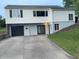 Two-story home with light siding, a dark garage door, and a concrete driveway leading to the side entrance at 249 Spring St, Plainfield, IN 46168