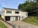 Two-story home with light siding, dark garage door, and a concrete driveway surrounded by mature trees and lawn at 249 Spring St, Plainfield, IN 46168