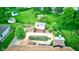 Aerial view of a backyard featuring an in-ground pool, sheds, and a lush green lawn surrounded by trees at 286 N Greenbriar Dr, Greenwood, IN 46142
