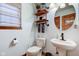 Updated half bathroom featuring a pedestal sink, wood shelves, and stylish fixtures at 286 N Greenbriar Dr, Greenwood, IN 46142