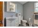 Bathroom with a white vanity, toilet, small linen cabinet, and gray walls at 286 N Greenbriar Dr, Greenwood, IN 46142