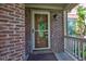 Elegant wood front door with glass detailing, set against a brick exterior and covered porch at 286 N Greenbriar Dr, Greenwood, IN 46142