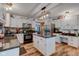 Modern kitchen with white cabinets, black appliances, a center island, and durable wood-look flooring at 286 N Greenbriar Dr, Greenwood, IN 46142