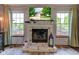 Cozy living room featuring a charming brick fireplace, mantle, and large windows with natural light at 286 N Greenbriar Dr, Greenwood, IN 46142