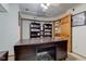 Home office with a large dark wood desk, neutral walls and carpeting, and built in book shelves at 286 N Greenbriar Dr, Greenwood, IN 46142