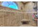 Tiled shower features a corner seat, window, and built in shelving for storage at 286 N Greenbriar Dr, Greenwood, IN 46142